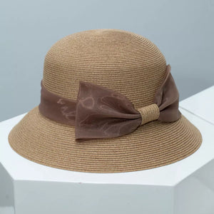 Chic cloche sun hat in beige straw with a sheer ribbon bow detail.