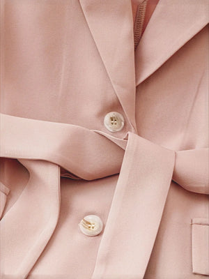 Sleeveless blush blazer with a belted waist and button detail