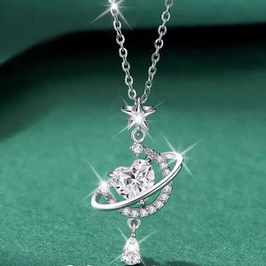 Silver celestial heart pendant necklace with star and planet ring, adorned with clear crystals.