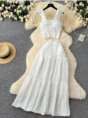 White textured two-piece set with ruffled crop top and tiered skirt.