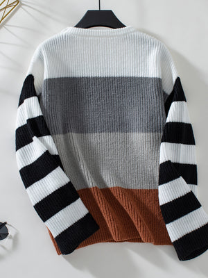 Colorblock stripe ribbed knit sweater with white, gray, and rust body and black and white striped sleeves.