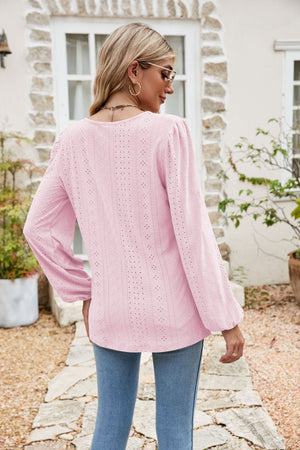 Blush pink eyelet yoke blouse with blouson sleeves and a textured pattern.
