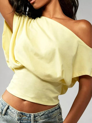 Yellow asymmetrical crop t-shirt with draped fit and off-the-shoulder neckline.