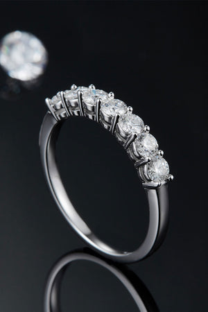 Silver band ring with seven round-cut moissanite stones.