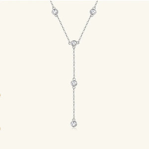 Silver lariat necklace with five bezel-set moissanite stones on a delicate chain.