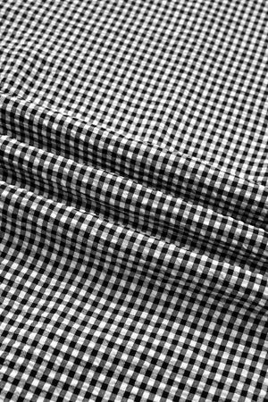 Black and white gingham polyester shirt with ruffled sleeves and bow tie detail.