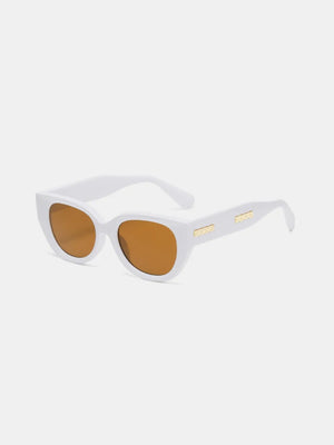 White cat eye sunglasses with amber lenses and gold accents on the temples.