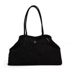 Black suede slouchy shoulder bag with drawstring and buckle detail.