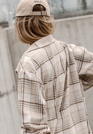 Oversized plaid shacket with attached hoodie in beige and brown plaid, shown from the back.