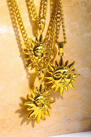 Gold sunburst pendant necklaces with curb chains, featuring detailed sun face charms.