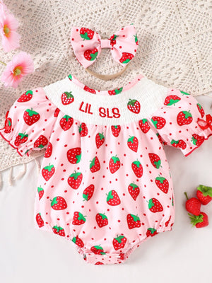 Baby pink cotton smocked one-piece with strawberry print and bow headband.
