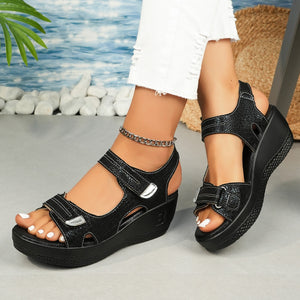 Black textured wedge sandals with adjustable straps and contrast stitching.
