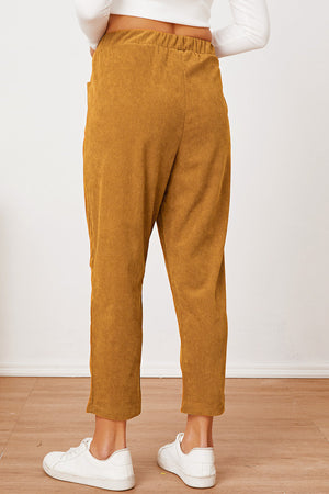 Mustard corduroy barrel-leg utility pants with elastic waist and pockets.