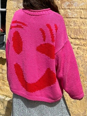 Hot Pink knit sweater with red abstract smiley face graphic on back.