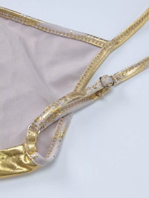 Elegant cream maxi gown detail with abstract gold pattern and adjustable straps.