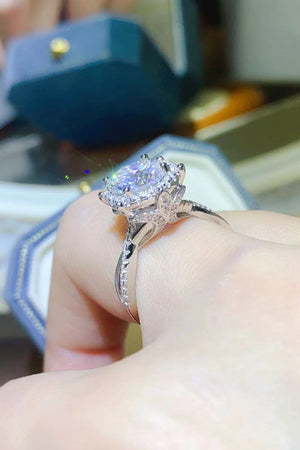 Silver moissanite halo engagement ring with intricate band detail.