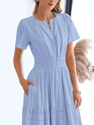 Light blue tiered midi dress with V-neck, short sleeves, smocked waist, and pockets.