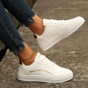 White lace-up casual sneakers with gold accents and a heart anklet.