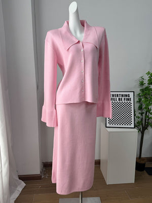 Pink ribbed knit cardigan with collar and button-down front, paired with a matching midi skirt.