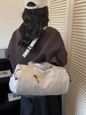 Light gray nylon travel bag with quilted details and zippered pockets.