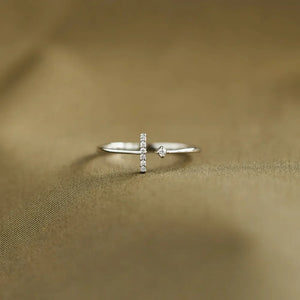Silver bar and dot ring with small diamonds on a textured gold background