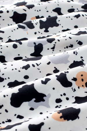 White blouse with black and tan abstract print and ruffle detail.