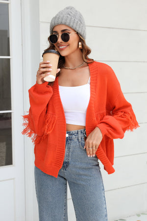 Orange acrylic cardigan with fringe sleeves and balloon sleeves.