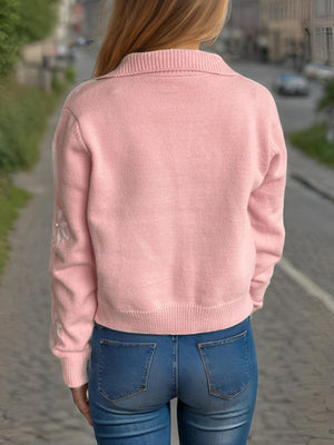 Blush pink knit cardigan with pearl snowflake embellishments on sleeve.