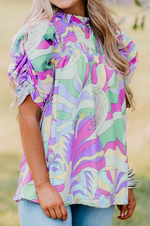 Multicolor smocked puff sleeve blouse with psychedelic print and ruffled cuffs.
