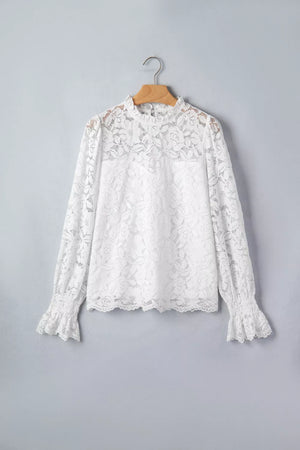 White lace blouse with ruffled neckline and cuffs, long sleeves.