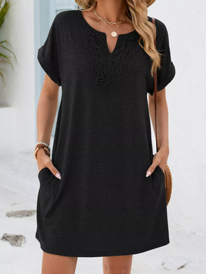 Black lace-trimmed V-neck pocket dress with short sleeves and cuffed hems.