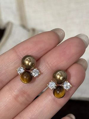 Spherical Tiger Eye Stone Stud Earrings with clear accents and gold-tone spheres.