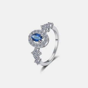 Silver ring with blue sapphire halo and diamond cluster accents