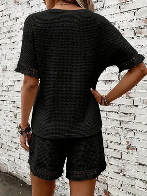 Black textured knit set with fringe detail on short sleeves and hem.