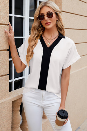 White blouson top with black contrast V-neck panel and collar.