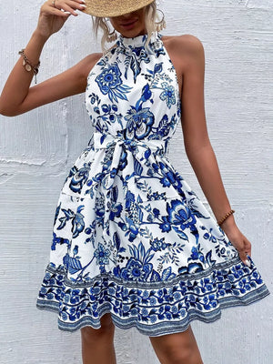 Women's royal blue floral print halter dress with tie waist and ruffled hem.