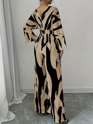 Abstract print wide leg jumpsuit with V-neck, belted waist, and flared sleeves.