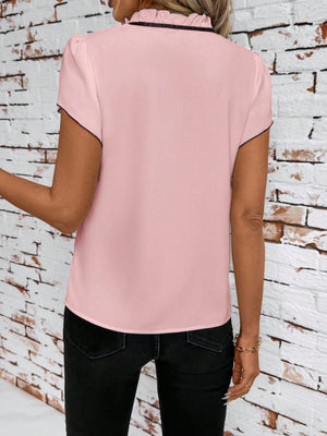 Pink maternity blouse with ruffled tie-neck and black trim, short sleeves.