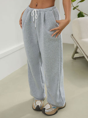 Light gray relaxed sweatpants with pleat-front detail and drawstring waist.