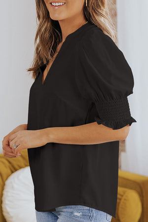 Black puff sleeve v-neck blouse with smocked cuffs.
