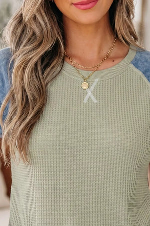 Color block waffle knit t-shirt with crew neck and cuffed sleeves in light green and blue.