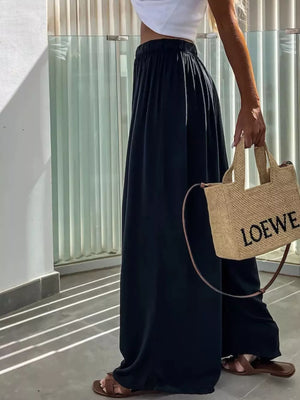 Dark blue cotton maternity pants with paperbag waist and wide leg, styled with sandals.