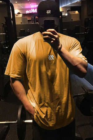 Gold oversized t-shirt with a small white logo detail on the chest.