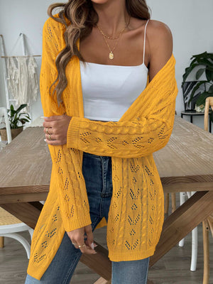 Openwork diamond knit duster cardigan in gold with long sleeves and open front, styled with a white cami.