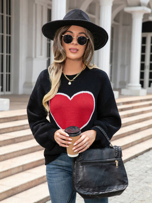 Black acrylic sweater with a large red heart motif and balloon sleeves.