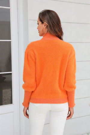 Fluffy mock neck sweater in tangerine with balloon sleeves.