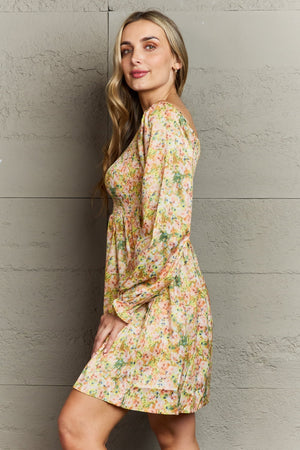 Floral smocked bodice mini dress with long sleeves and a square neckline.