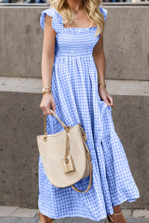 Blue gingham smocked maxi dress with flutter sleeves and tiered skirt.