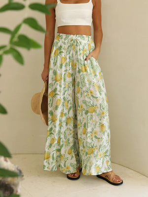 Palazzo trousers with white base and all-over yellow pineapple and green leaf print.