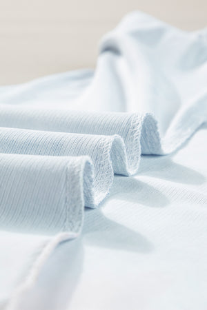 Distressed Americana tank top in dusty blue, showing ribbed texture and rolled hem detail.